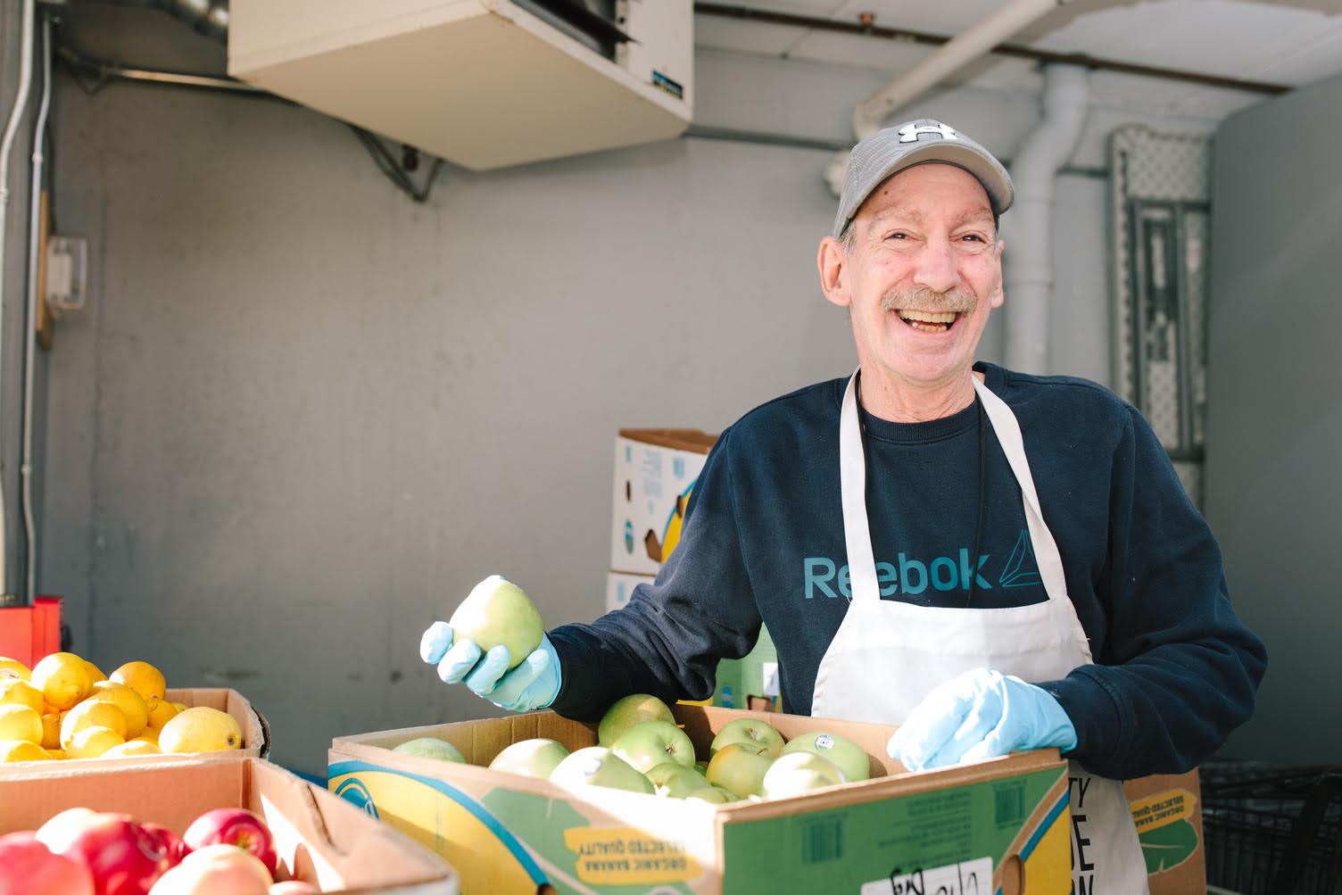 A volunteer holding fresh produce in the Mission kitchen