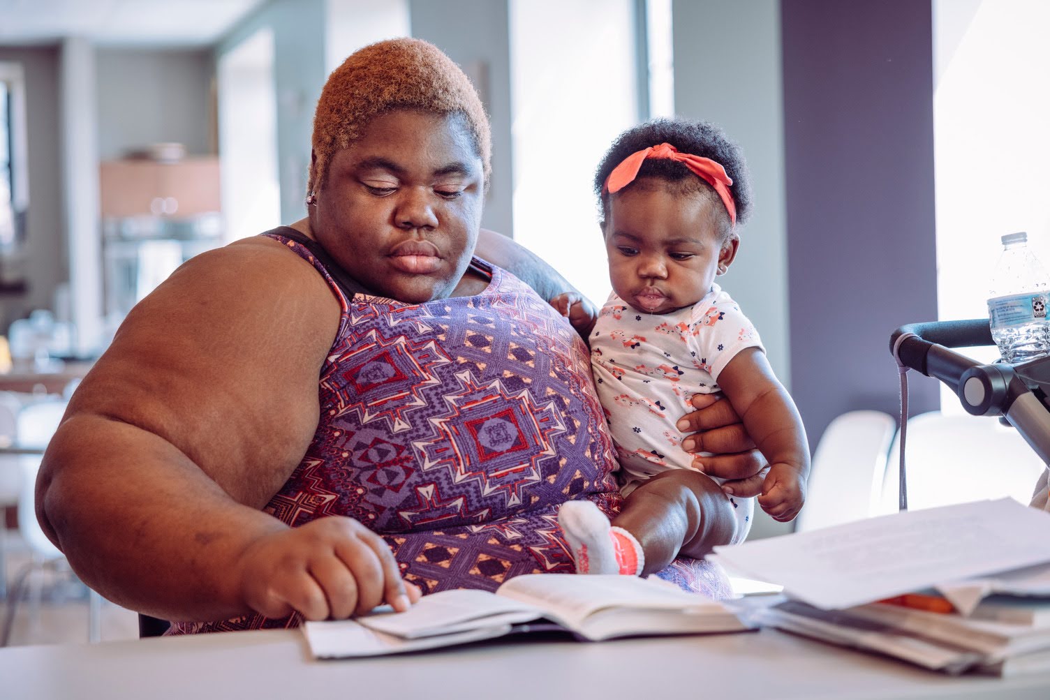 A mother holding her child while completing paperwork